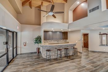 A modern kitchen with a bar and stools.